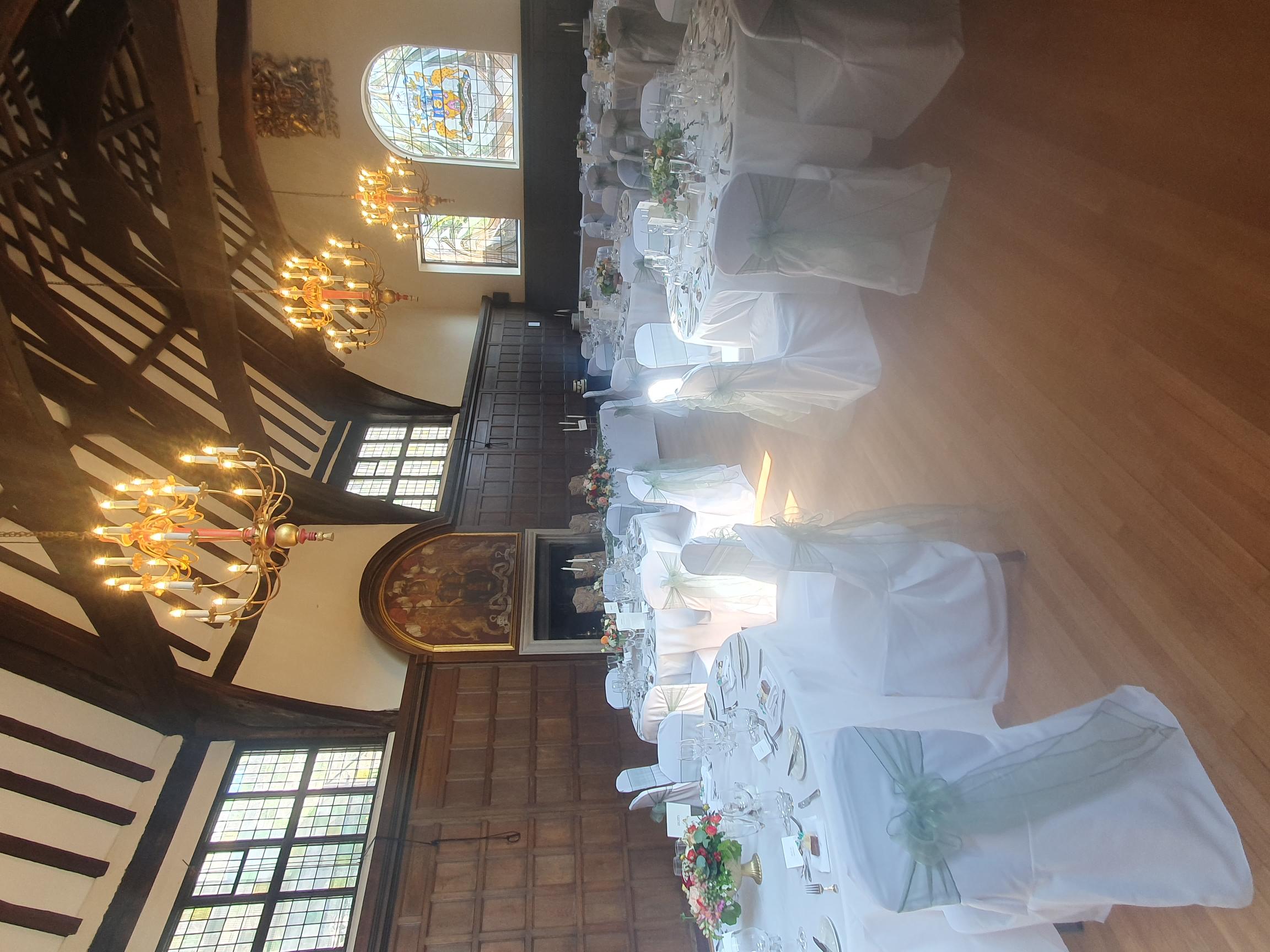 A view of a large open hall, set up with seating for a wedding reception