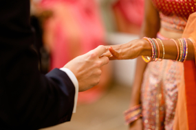 Photo of a man placing a ring on a woman's hand