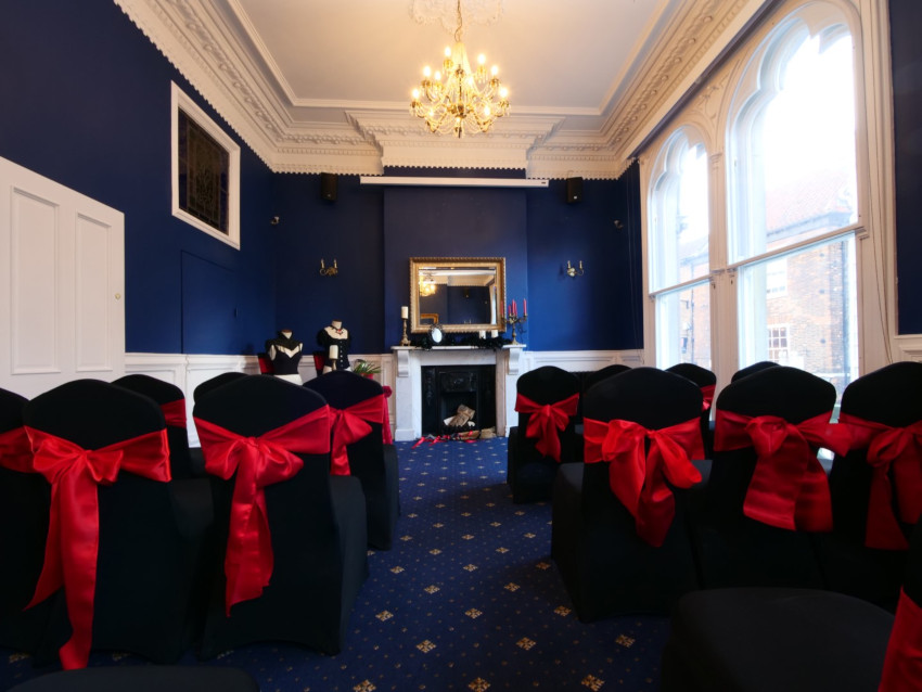 Black wedding chairs with red bows from behind