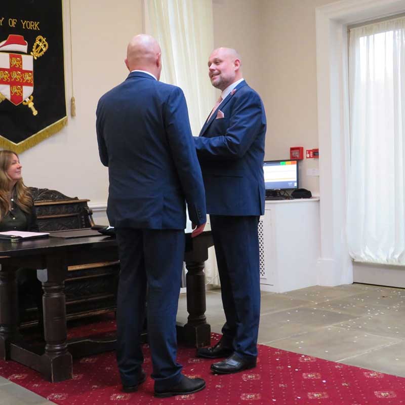 Two grooms saying their vows in front of the registrar