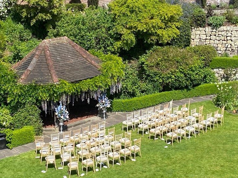An image taken from above a wedding ceremony at Grays Court in which all of the chairs have been arranged on a green lawn ready to receive guests