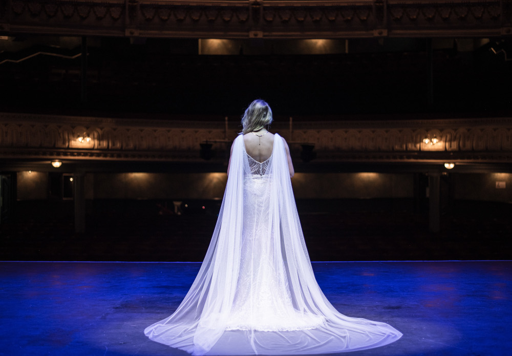 Bride standing on stage facing seats